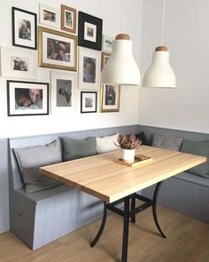 a room with a couch, table and pictures on the wall above it is shown