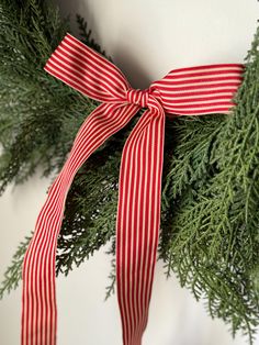 a red and white striped ribbon on a wreath