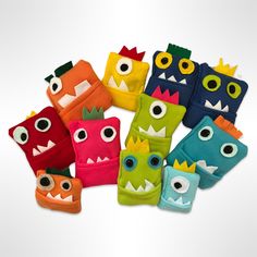 there are many different colored monster mitts on the white surface with eyes and mouths