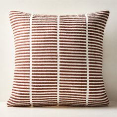 a brown and white striped pillow sitting on top of a table