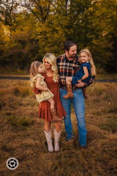 a man, woman and child are posing for a photo in a field with trees