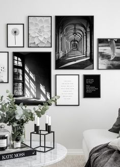 a living room with white walls and pictures on the wall