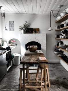 a rustic kitchen with an oven and wooden table