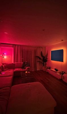 a living room filled with furniture and red lights on the walls, along with a flat screen tv