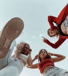 three young women standing in the air with their feet on each other's ankles