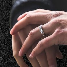 two people holding each other's hands with their wedding rings on top of them