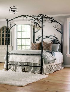 a bedroom with a canopy bed and white rugs on the wooden floor next to it