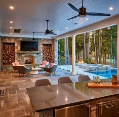 an outdoor living area with fireplace, couches and chairs next to a swimming pool