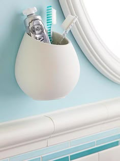 there is a toothbrush holder with two toothpastes in it on the wall