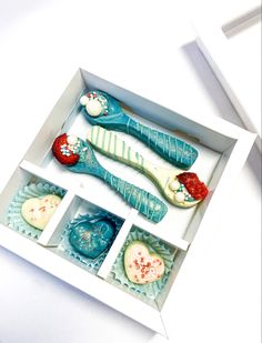 three decorated toothbrushes in a box on a white surface with red, white and blue decorations