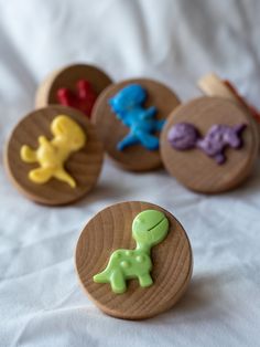 four wooden buttons with different designs on them