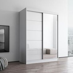 an empty room with a large mirror on the wall and white furniture in front of it