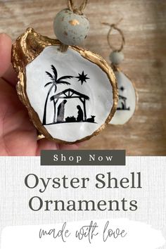 the oyster shell ornament is being held by someone's hand