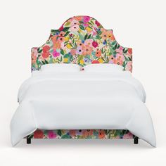 an upholstered bed with colorful floral headboard