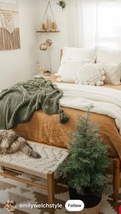 a bedroom with white walls and wooden floors, decorated in neutral colors including green accents