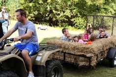 a man riding on the back of a four wheeler with kids in front of him