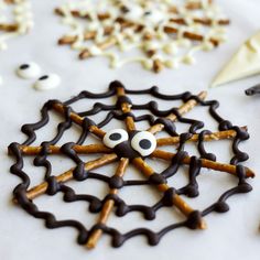 some pretzels are decorated with googly eyes and sticks to look like spider webs