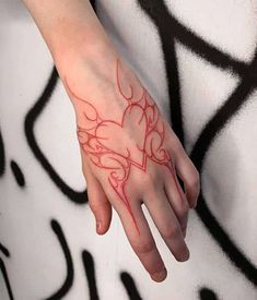 a woman's hand with red ink on it and an abstract design in the background