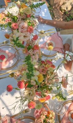 two people sitting at a table with flowers on it