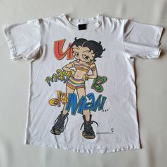 "An awesome Betty Boop tee from the 90s with a Changes tag. It's 2 sided and 100% cotton. It's in great condition, not much wear but does have minor marks on the sleeve and faint stains on the front below the graphic, which is not noticeable. Shoulder - 18.5\" Chest - 22\" Length - 27\" Sleeve - 8\"" Make Art Make Out Make Money Shirt, Betty Boop Graphic Tee, Cheap Pop Culture Graphic T-shirt, Betty Boop Shirt Outfit, Vintage Betty Boop Shirt, 90s Style Multicolor Tops For Fan Merchandise, 90s Inspired Multicolor Cotton T-shirt, Funny T-shirt, Tee Shirt Designs Graphics