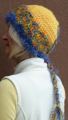 a woman with blonde hair wearing a yellow and blue knitted beanie on her head