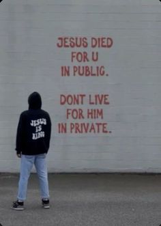 a man standing in front of a white wall with words on it that read jesus died for u in public don't live for him in private