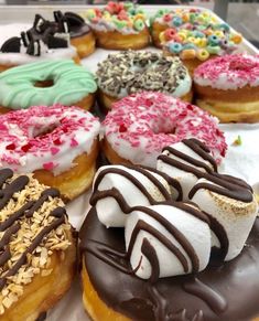 there are many different types of donuts on the tray