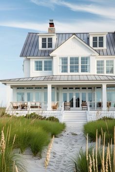 a large white house sitting on top of a sandy beach