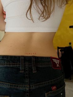 the back of a woman's stomach with an arrow tattoo on her left side