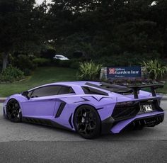 a purple sports car is parked on the street