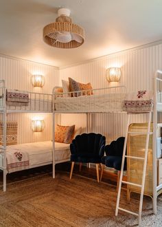 a bedroom with bunk beds and chairs in the corner, next to a ladder that leads up to another bed