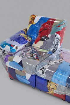 a couch made out of plastic wrap and various colored pieces of clothing sitting on top of each other