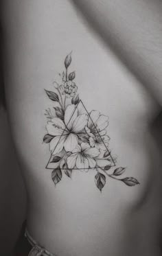 a black and white photo of a woman's chest with flowers on it, in the shape of a triangle