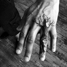 a person with a tree tattoo on their hand