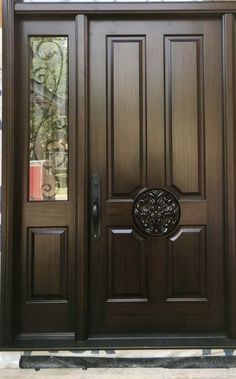 a wooden door with two sidelights and an ornamental design on the top half of it