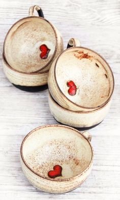 three white bowls with red hearts on them