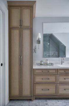 a bathroom with two sinks and wooden cabinets in it's own area, along with a large mirror on the wall