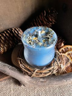 a blue cup filled with something next to some pine cones and dried orange peels