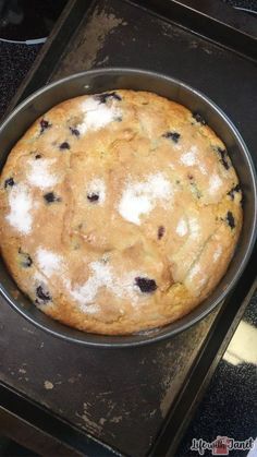 a cake in a pan sitting on top of an oven burner with powdered sugar