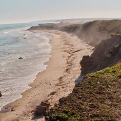 the beach is next to an ocean cliff