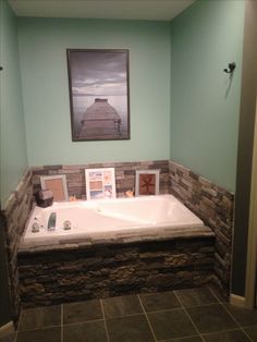 a bathroom with a large jacuzzi tub next to a painting on the wall