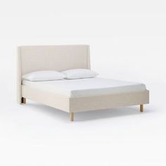 a bed with white sheets and pillows on it