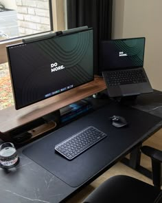 two computer monitors sitting next to each other on top of a black desk in front of a window