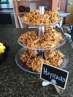 three tiered trays filled with food on top of a counter next to a sign