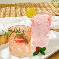 two pink glasses sitting on top of a white tray