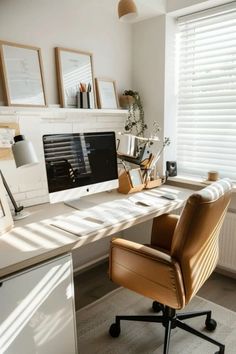 an office desk with a computer on top of it next to a window covered in blinds