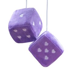 two purple dices with hearts hanging from strings