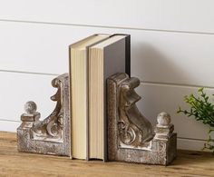 an open book on a wooden table next to a plant