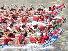 a group of people riding on the back of a dragon boat