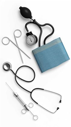 medical equipment including a stethoscope, an armband and a wallet on a white surface